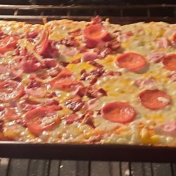 Members pizza creation in the oven