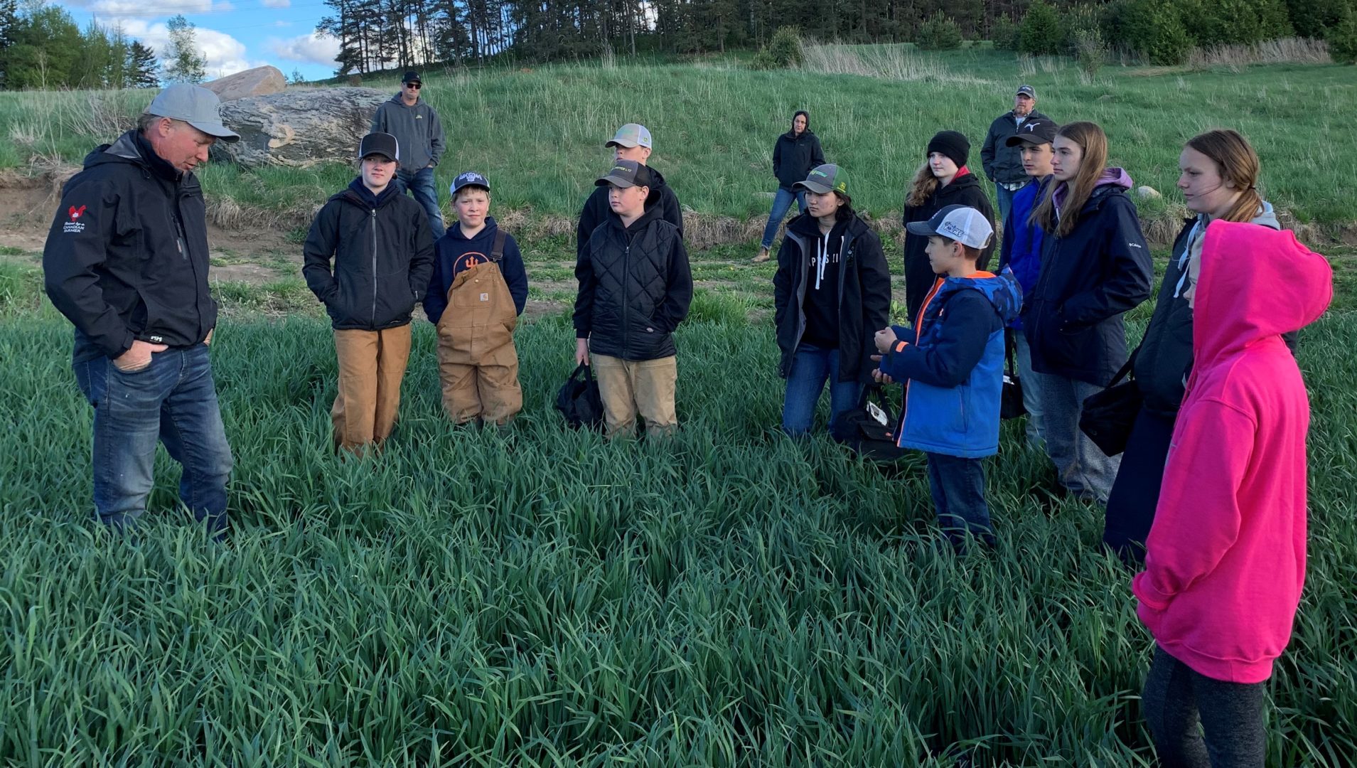 Members in a field at a crops meeting