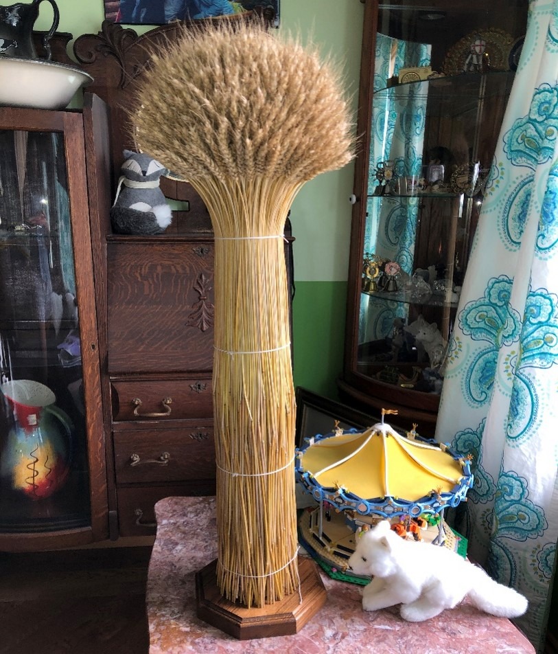 Joyce's completed wheat sheaf on a stand on a table.